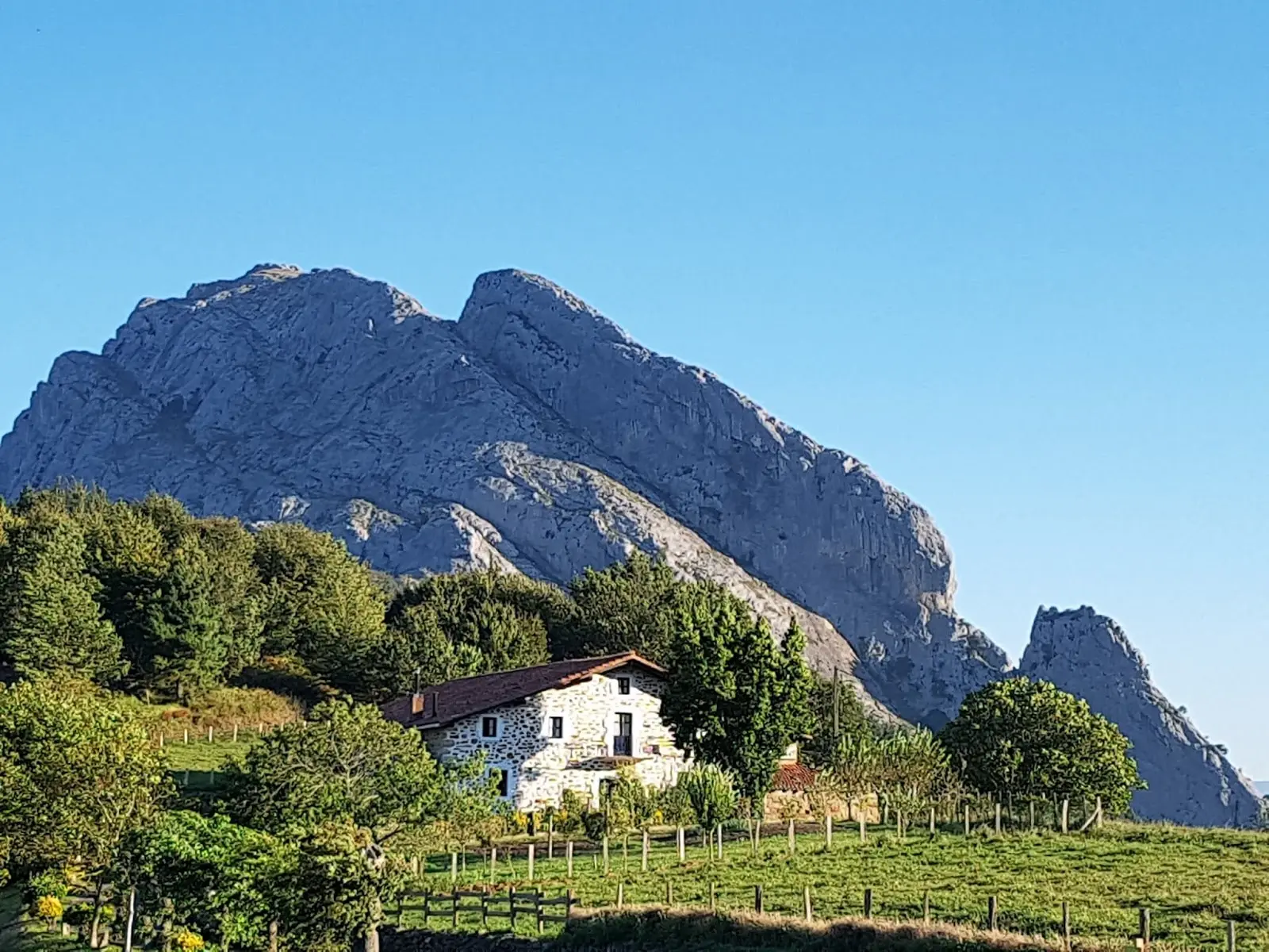 Caserío bajo las peñas calizas del Parque Natural de Urkiola